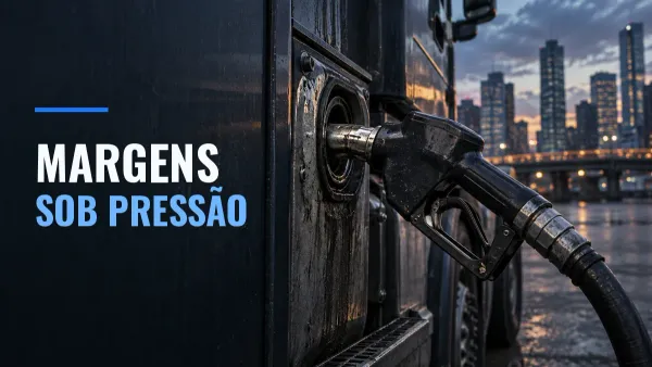 Bico de diesel conectado a um caminhão diante de edifícios urbanos ao anoitecer.